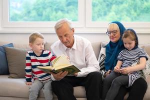 grands-parents musulmans modernes avec petits-enfants lisant le coran photo