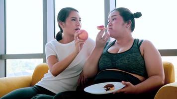 jeune femme suggérant à une femme potelée de manger une pomme dans la chambre. photo