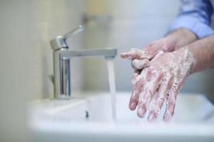 coronavirus mâle se laver les mains dans la salle de bain photo