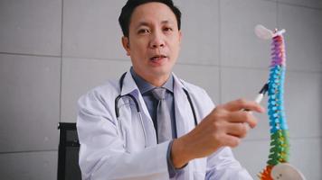 un médecin de sexe masculin explique la physiologie du corps humain par vidéoconférence. photo
