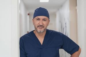 portrait d'un médecin de sexe masculin mature dans un couloir d'hôpital moderne et animé. photo