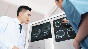 médecin et assistants médicaux discutant du résultat du diagnostic sur un film radiographique. photo