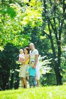 heureux jeune couple avec leurs enfants s'amuser au parc photo