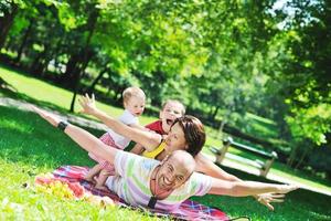 heureux jeune couple avec leurs enfants s'amuser au parc photo