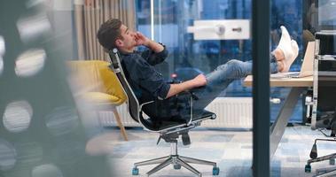 homme d'affaires assis avec les jambes sur le bureau photo