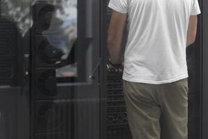 ingénieur de centre de données utilisant un ordinateur portable. installation spécialisée dans la salle des serveurs avec un administrateur système masculin coréen travaillant avec un réseau de protection des données pour la cybersécurité. photo