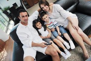 famille regardant la télévision à écran plat à la maison moderne à l'intérieur photo