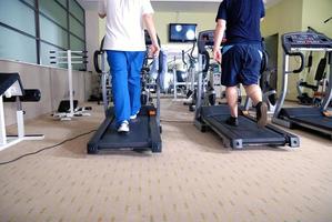 homme qui court sur un tapis roulant dans une salle de sport photo