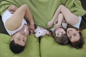 jeune famille heureuse prend son petit déjeuner au lit photo