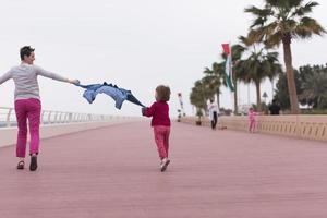 mère et jolie petite fille sur la promenade au bord de la mer photo