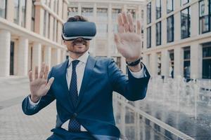 employé de bureau excité en costume formel vérifiant les informations dans la réalité virtuelle photo