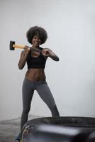 séance d'entraînement de femme noire avec un marteau et un pneu de tracteur photo