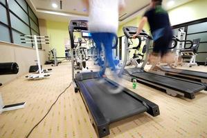 homme qui court sur un tapis roulant dans une salle de sport photo