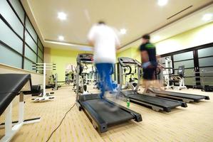 homme qui court sur un tapis roulant dans une salle de sport photo