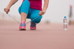 jeune femme attachant des lacets sur des baskets photo