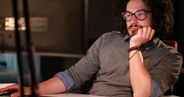 homme travaillant sur ordinateur dans un bureau sombre photo