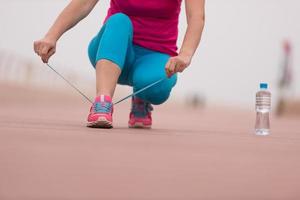 jeune femme attachant des lacets sur des baskets photo