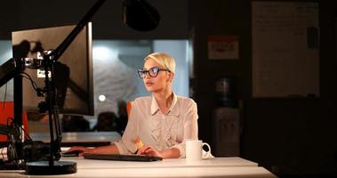 femme travaillant sur ordinateur dans un bureau sombre photo