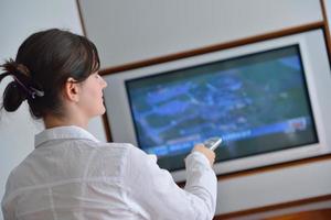 jeune femme regardant la télé à la maison photo