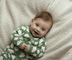 mignon petit bébé jouant avec les mains et souriant photo