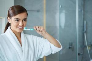 jeune jolie femme se brosser les dents