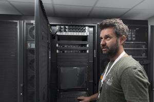 ingénieur du centre de données utilisant un clavier sur une installation spécialisée dans la salle des serveurs d'un superordinateur avec un administrateur système masculin photo