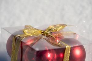 Boule de Noël en boîte sur la neige fraîche photo