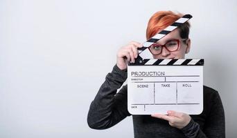 Redhead woman holding movie clapper sur fond blanc photo