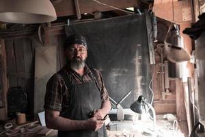 maître artisan cuillère dans son atelier avec des produits et des outils en bois faits à la main photo