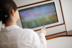 jeune femme regardant la télé à la maison photo