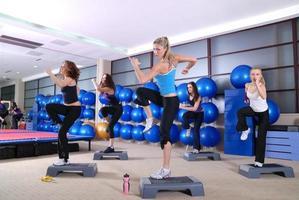 un groupe de femmes exerçant dans le club de fitness. photo