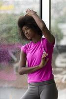 portrait de jeune femme afro-américaine dans la salle de gym tout en écoutant de la musique photo