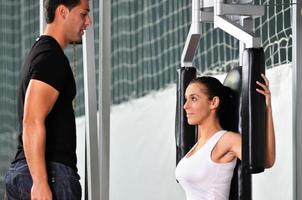 femme dans le fitness gim travaillant avec un entraîneur personnel photo