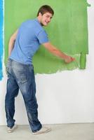 beau jeune homme peinture mur blanc en couleur photo
