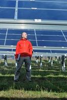 ingénieur utilisant un ordinateur portable sur le terrain de l'usine de panneaux solaires photo