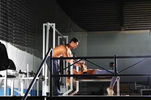 femme dans le fitness gim travaillant avec un entraîneur personnel photo