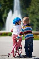 garçon et fille dans le parc apprenant à faire du vélo photo