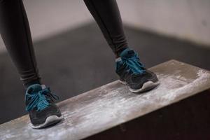 femme noire effectue des sauts de boîte au gymnase photo