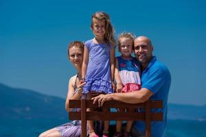 portrait de jeune famille heureuse avec des filles au bord de la mer photo