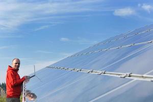 ingénieur utilisant un ordinateur portable sur le terrain de l'usine de panneaux solaires photo