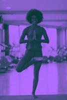 femme afro-américaine faisant du yoga dans la salle de sport photo