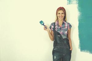 femme souriante heureuse peignant l'intérieur de la maison photo