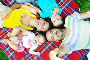 heureux jeune couple avec leurs enfants s'amuser au parc photo