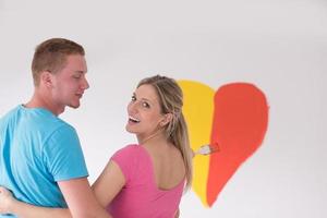 un couple peint un coeur sur le mur photo