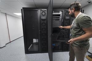 ingénieur du centre de données utilisant un clavier sur une installation spécialisée dans la salle des serveurs d'un superordinateur avec un administrateur système masculin photo