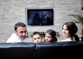 famille regardant la télévision à écran plat à la maison moderne à l'intérieur photo