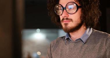 homme travaillant sur ordinateur dans un bureau sombre photo