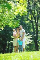 heureux jeune couple avec leurs enfants s'amuser au parc photo