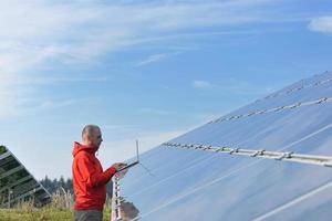 ingénieur utilisant un ordinateur portable sur le terrain de l'usine de panneaux solaires photo