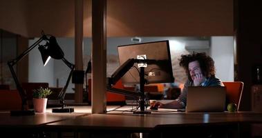 homme travaillant sur ordinateur dans un bureau sombre photo